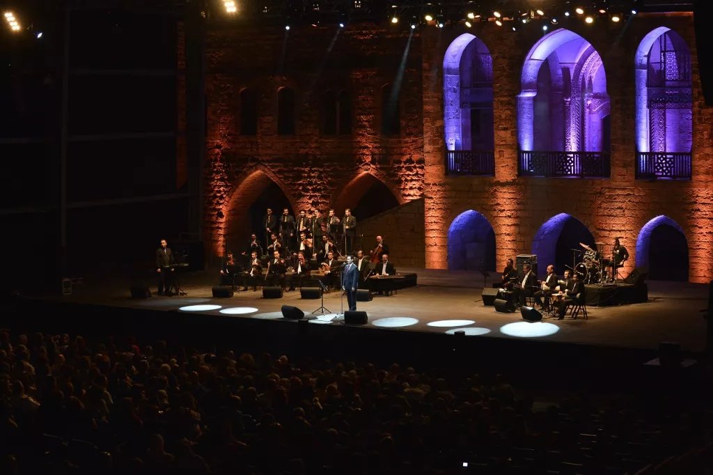 Hamam Khairy performing with his ensemble on a warmly lit stage